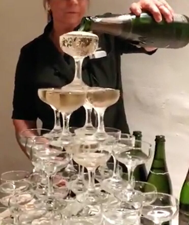 event bartender pouring champagne over tower